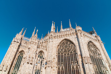 Milan Duomo back side with giant stained-glass windows in morning light.