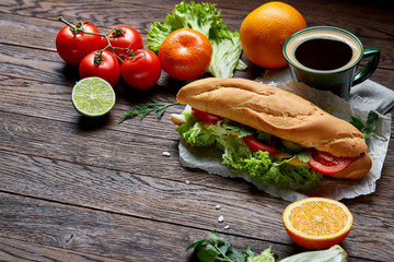 Lunch sandwich with cheese and vegetables served with citrus and coffee, selective focus, close-up, top view
