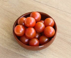 Cherry tomatoes on wooden background in kitchen