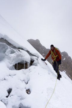male mountain climber on a very steep glacier in the Cordillera Blanca in bad weather