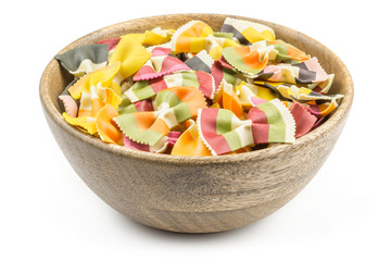 Farfalle pasta with vegetables in a wood bowl isolated on white background raw classic traditional Italian.