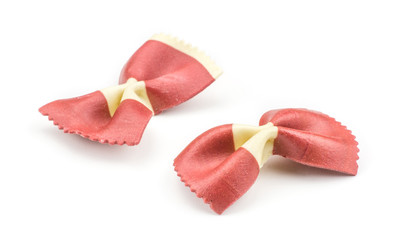 Farfalle pasta with red beet and paprika isolated on white background two raw classic traditional Italian.