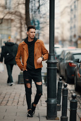 Obraz premium Model looking man stand near the wall and look on his watch