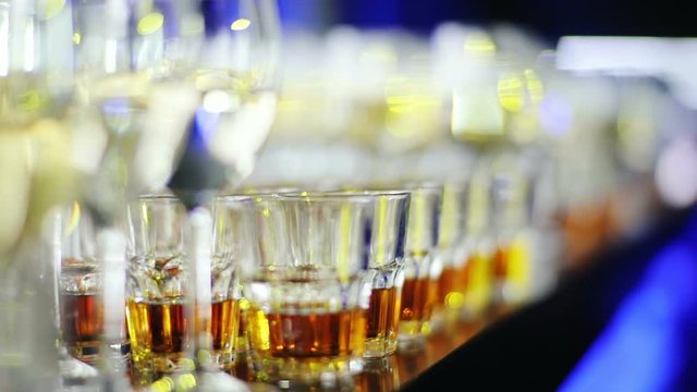 Glasses with different alcoholic drinks in bar space in the night club / glass closeup selective focus beverage corporate party buffet champagne wine cognac celebrate restaurant nobody liquor