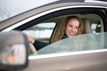 Pretty young woman driving her new car (shallow DOF; color toned image)