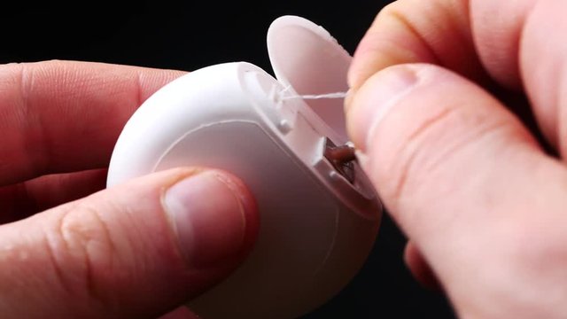 Closeup on young woman with dental floss