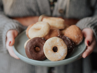 Junge Frau mit Teller mit Donuts