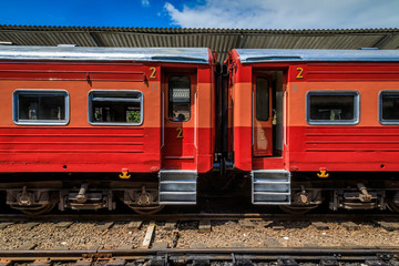 Fototapeta premium Auf dem Bahnhof wartet ein roter Zug auf Passagiere, Sri Lanka