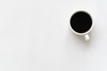 White ceramic coffee cup on white background. Copy space. Top view.