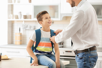 Fototapeta premium Man helping his son get ready for school