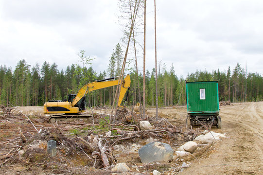 Excavator and cabins for forestry workers on a forest felling plot. Wood industry in Russia