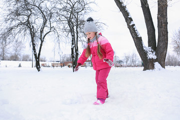 Cute girl in snowy park on winter vacation