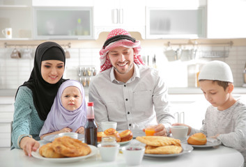 Obraz na płótnie Canvas Happy Muslim family having breakfast together at home