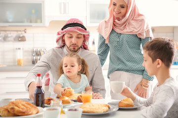 Obraz na płótnie Canvas Happy Muslim family having breakfast together at home
