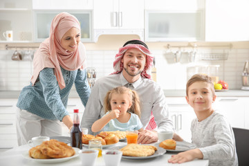 Happy Muslim family having breakfast together at home