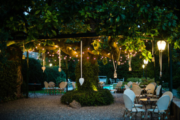 villa garden with large magnolia tree with many lanterns hanging from its branches