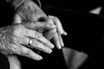 old woman holding the hand of young man - obrazy, fototapety, plakaty
