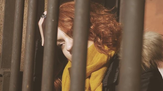 sad and pensive young woman behind bars:imprisoned in a wrong relation- close up