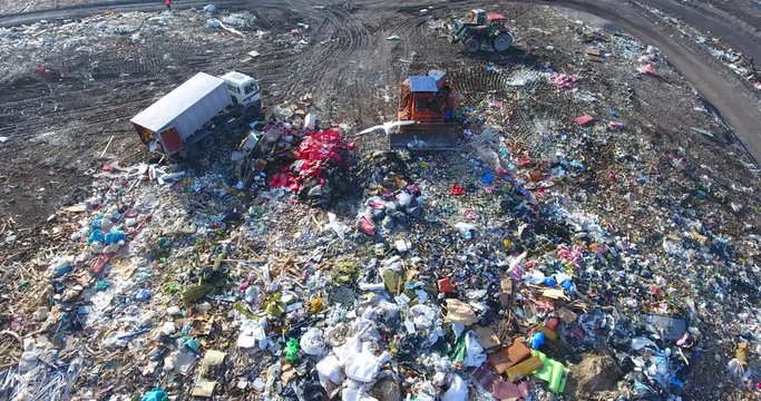 The landfill aerial activity - flying seagulls and crows, riding bulldozer and tractor, mountains of garbage and trash.