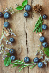 Beautiful vintage background or wallpaper frame of fresh wild blueberries on wood plank in top view flat lay with copy space. Blueberry is antioxidant food and have vitamin C. Healthy fruits concept.