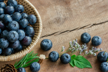 Fresh ripe wild blueberries heap in wooden basket and lay on wood table with copy space for background or wallpaper. Blueberry is antioxidant food and high vitamin C. Healthy fruits concept.