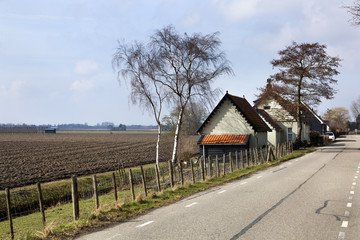 Fototapeta na wymiar Country road and a plowed field in Dutch polder landscape