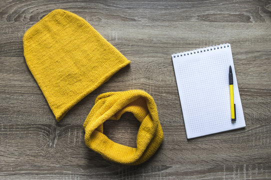 hand made background tree yellow snod scarf cap knitted with knitting needles facial smoothness mohair merino wool acrylic yarn notepad pen