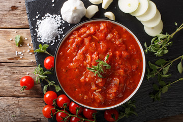 Neapolitan fresh pizzaiola sauce made with tomatoes, oregano, onions and garlic close-up. horizontal top view