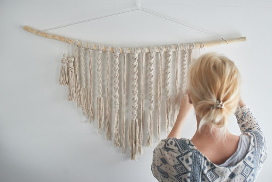 Macrame. Women's hobby. The girl makes a canvas of threads