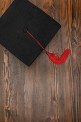 Top view of square academic cap on wood background