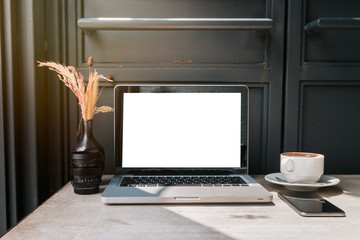 Front view of cup coffee,smartphone and laptop on table in office and background black