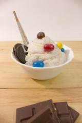 homemade bingsu and chocolate bar on wooden table with white background closeup.