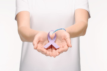 Obraz premium cropped shot of woman holding purple ribbon in hands isolated on white, world health day concept