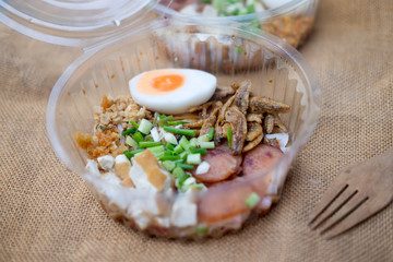 China noodle mixed with egg, sausage, pork, mushroom and tofu in box