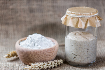 Rye natural leaven for bread in a glass jar. A living product. Spikelets. The concept of a healthy diet. Sourdough starter