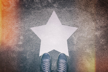 Sneakers on asphalt road with white star