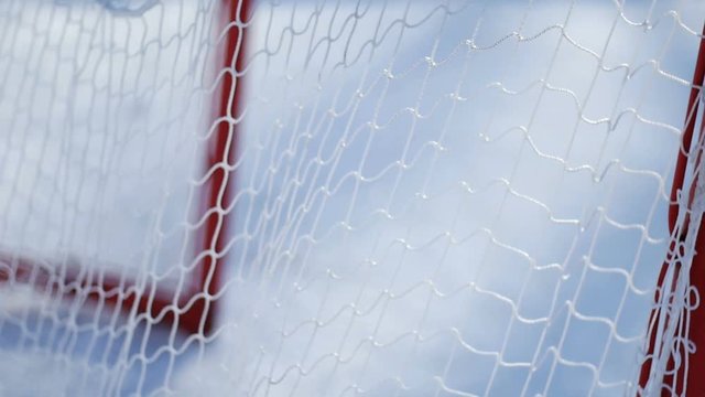 Close up slow motion hockey puck flies into the net