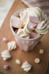  lovely marshmallow in a pink glass on a wooden board