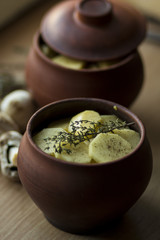 Meat in a clay pot on a wooden window sill