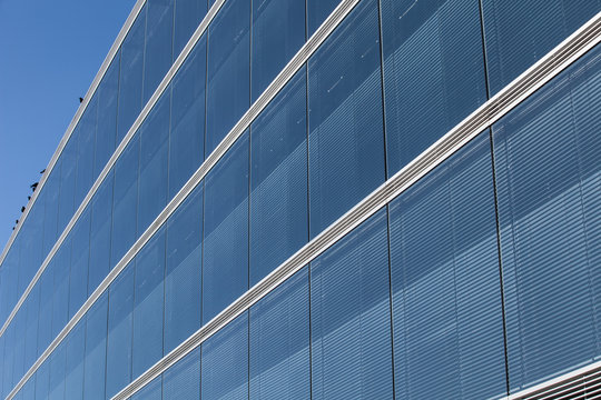Blaue Glasfassade mit Jalousien