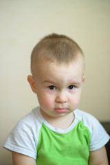 Naklejka premium Funny little boy showing emotions, looking serious. Caucasian child 2 years old. Closeup portriat.