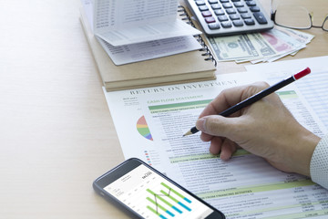 Businessman analysing saving deposit bank account in cash flow statement management with mobile application and left copy space.