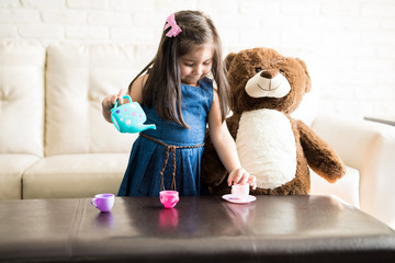 Little girl playing with a tea set