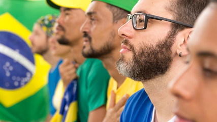 Group of fans watching a match and cheering brazilian team. - obrazy, fototapety, plakaty