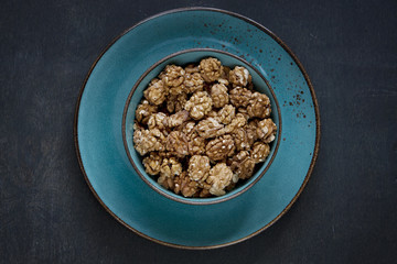 Close-up of a bowl with walnuts on a vintage wooden background. Top view, background.