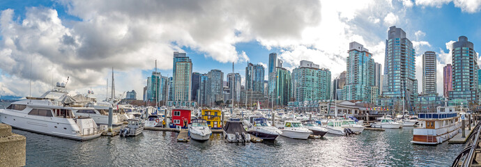 Fototapeta premium North American large city with high rise buildings near the ocean with yachts, boats and floating houses moored in the local port