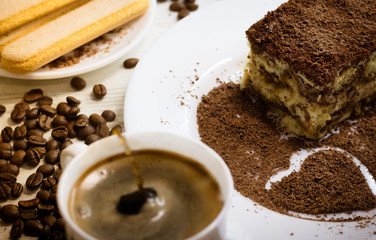 Tiramisu with cup of coffee, chocolate and coffee beans