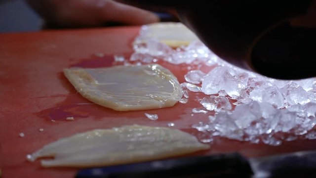 Chef put crushed ice on fresh raw squid