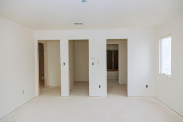 Fototapeta na wymiar New home construction interior room with unfinished wood floors and twin closets.