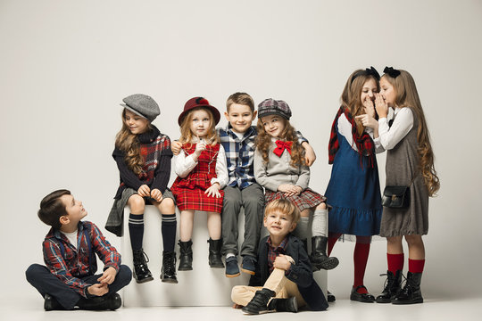 The group of beautiful girls and boys on a pastel background